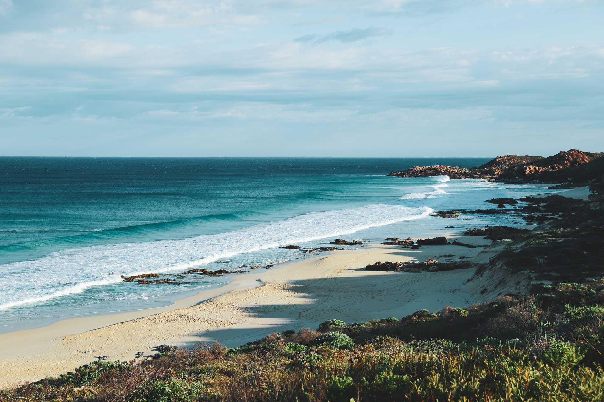 Remote beach with ocean waves and a clear sky